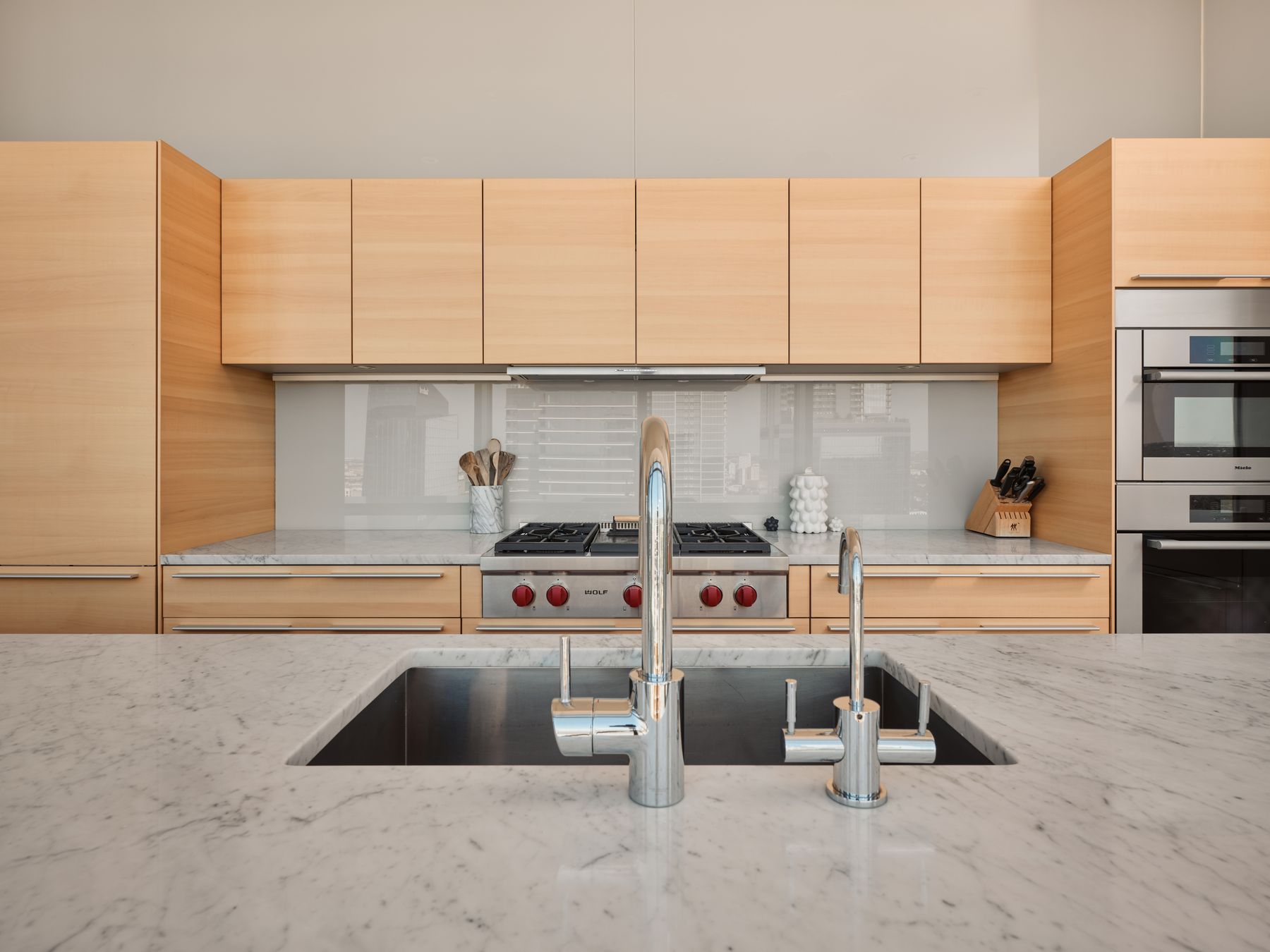 210 Lavaca Street, Unit 3504 Austin, TX 78701 - Photo 16 of 40 Kitchen featuring light brown cabinets, light stone countertops, backsplash, and appliances with stainless steel finishes