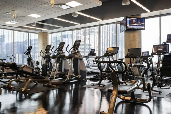 a room with gym equipment and large windows