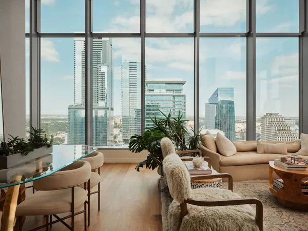 a living room with furniture and floor to ceiling windows