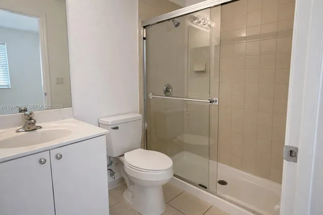 a bathroom with a shower sink vanity and toilet