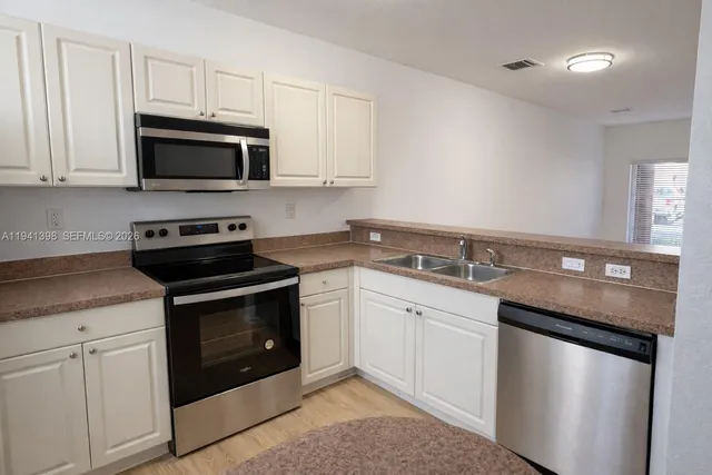 a kitchen with granite countertop white cabinets and white appliances