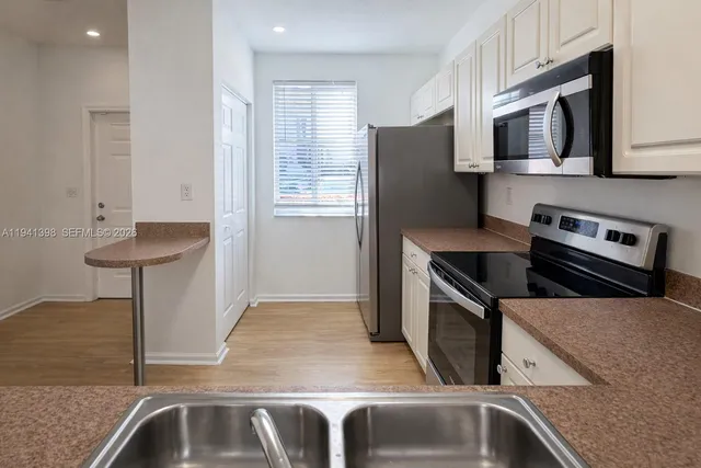 a kitchen with stainless steel appliances granite countertop a sink and a microwave