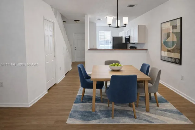 a view of a dining room with furniture wooden floor and a chandelier