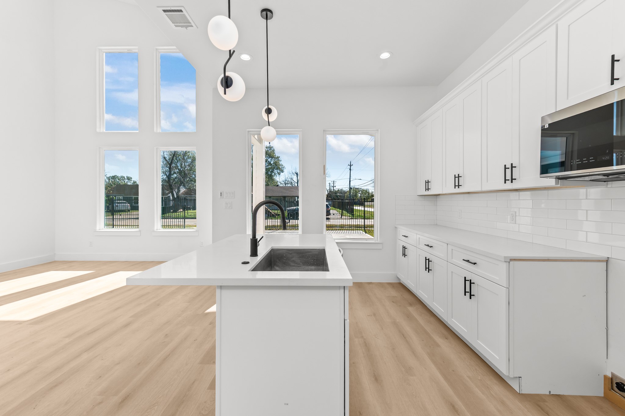5903 Doolittle Boulevard Houston, TX 77033 - Photo 12 of 30 a kitchen with cabinets a sink and a wooden floor