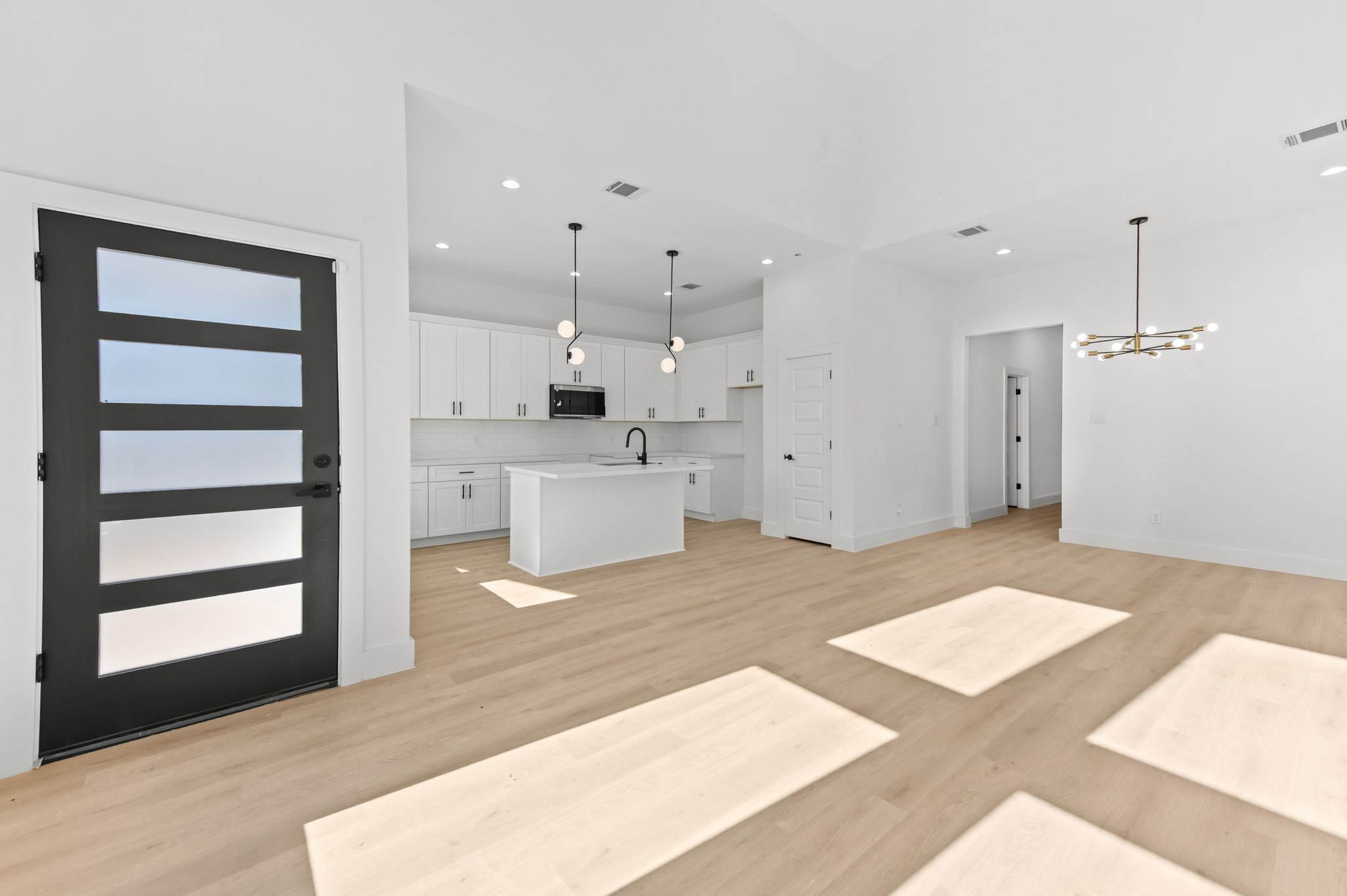 5903 Doolittle Boulevard Houston, TX 77033 - Photo 28 of 30 a large white kitchen with a white kitchen island a sink stainless steel appliances and cabinets