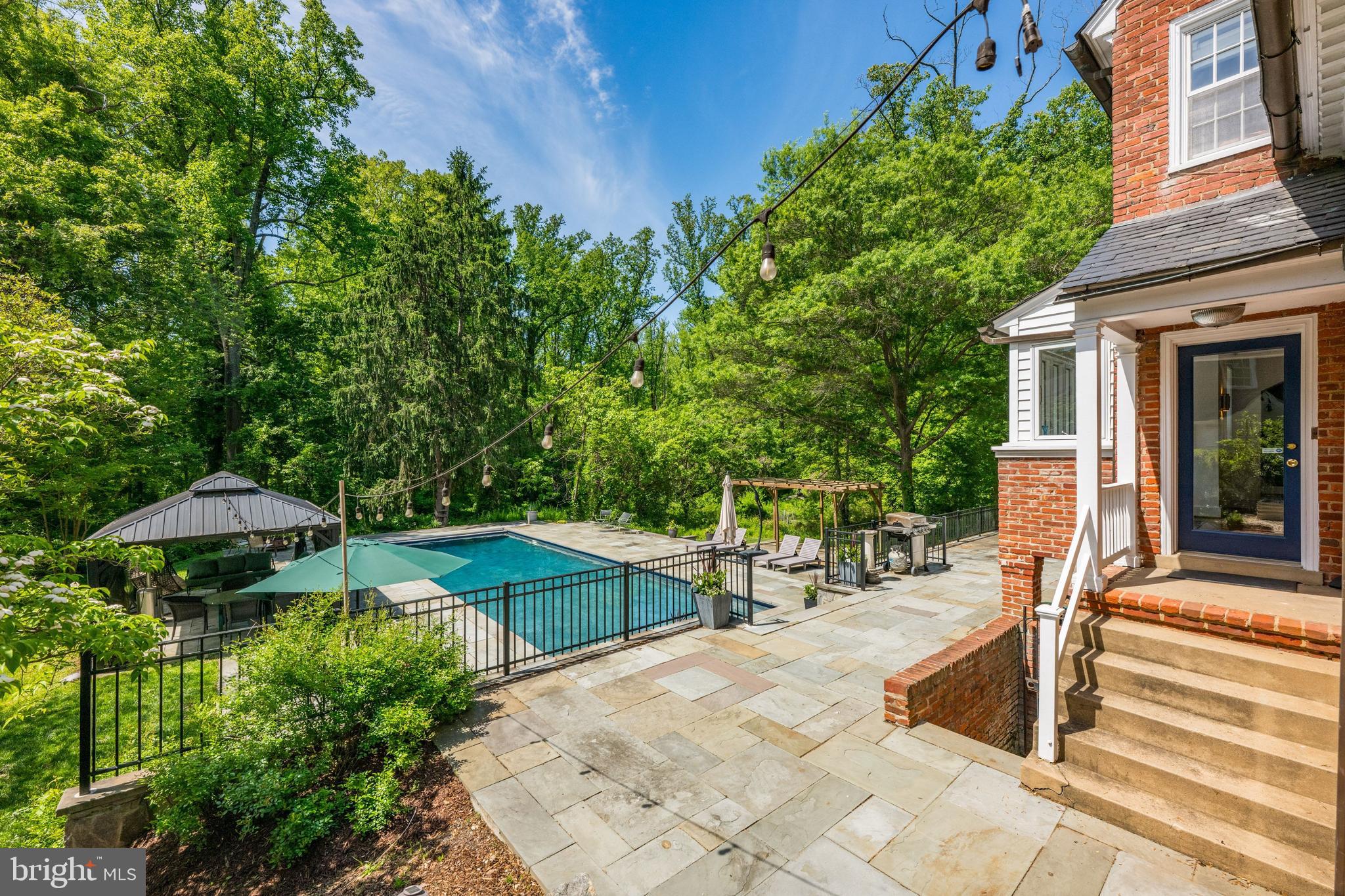 1702 Kalmia Road Northwest Washington, DC 20012 - Photo 41 of 55 a backyard of a house with table and chairs under an umbrella