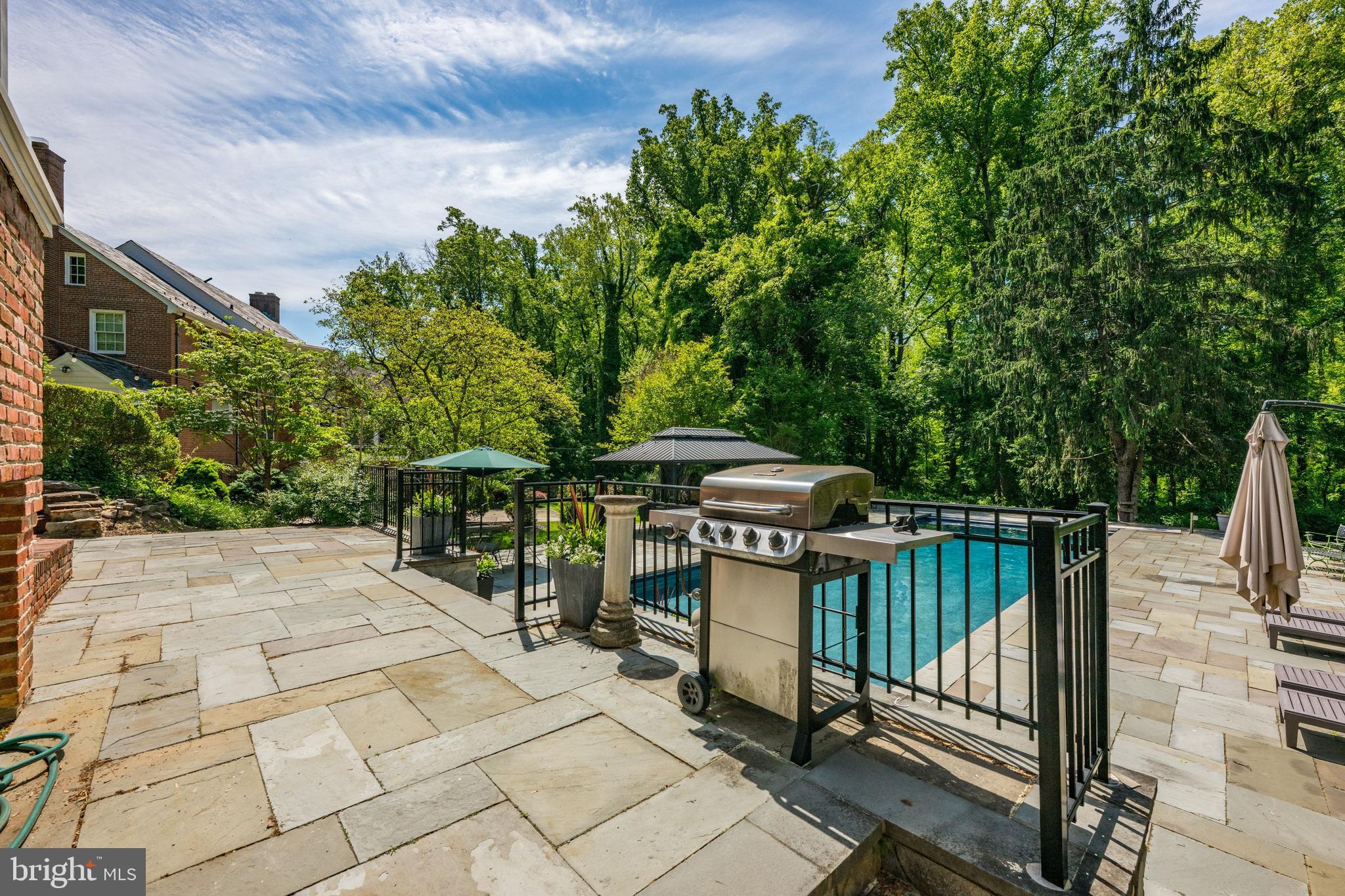 1702 Kalmia Road Northwest Washington, DC 20012 - Photo 43 of 55 a view of a patio with table and chairs under an umbrella with large trees