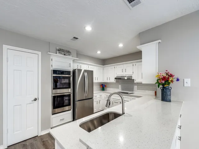 a kitchen with granite countertop a refrigerator and a sink