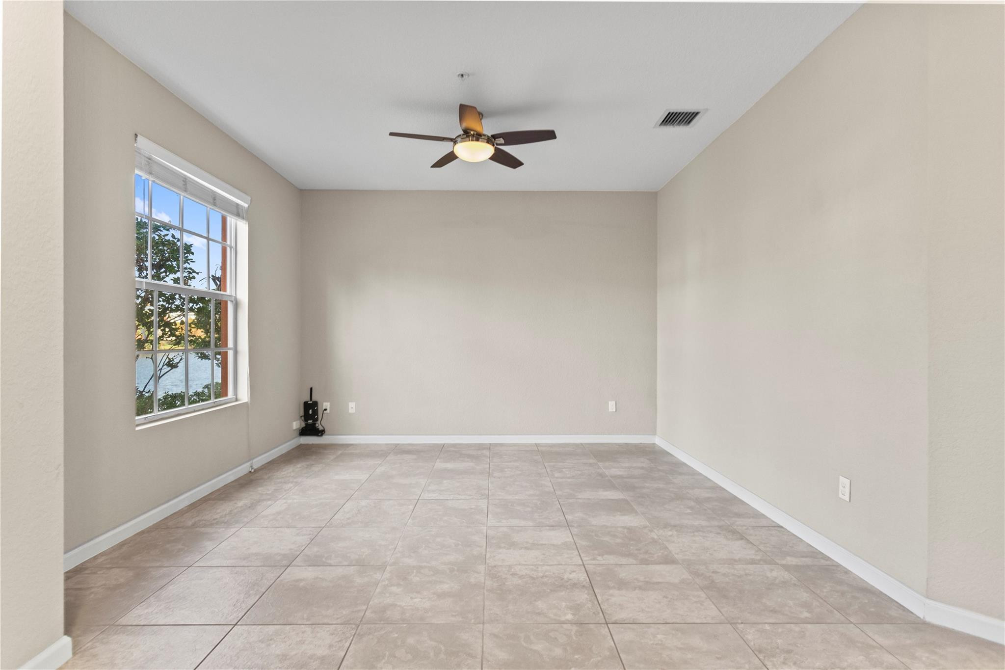 259 Southwest 7th Street, Unit 259 Pompano Beach, FL 33060 - Photo 12 of 87 an empty room with windows and chandelier fan