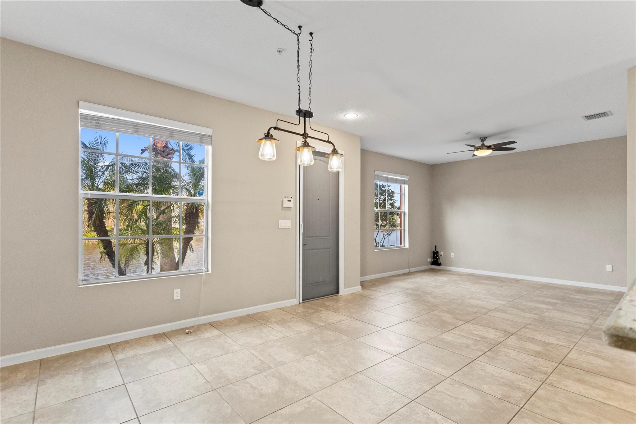 259 Southwest 7th Street, Unit 259 Pompano Beach, FL 33060 - Photo 14 of 87 an empty room with chandelier fan and windows