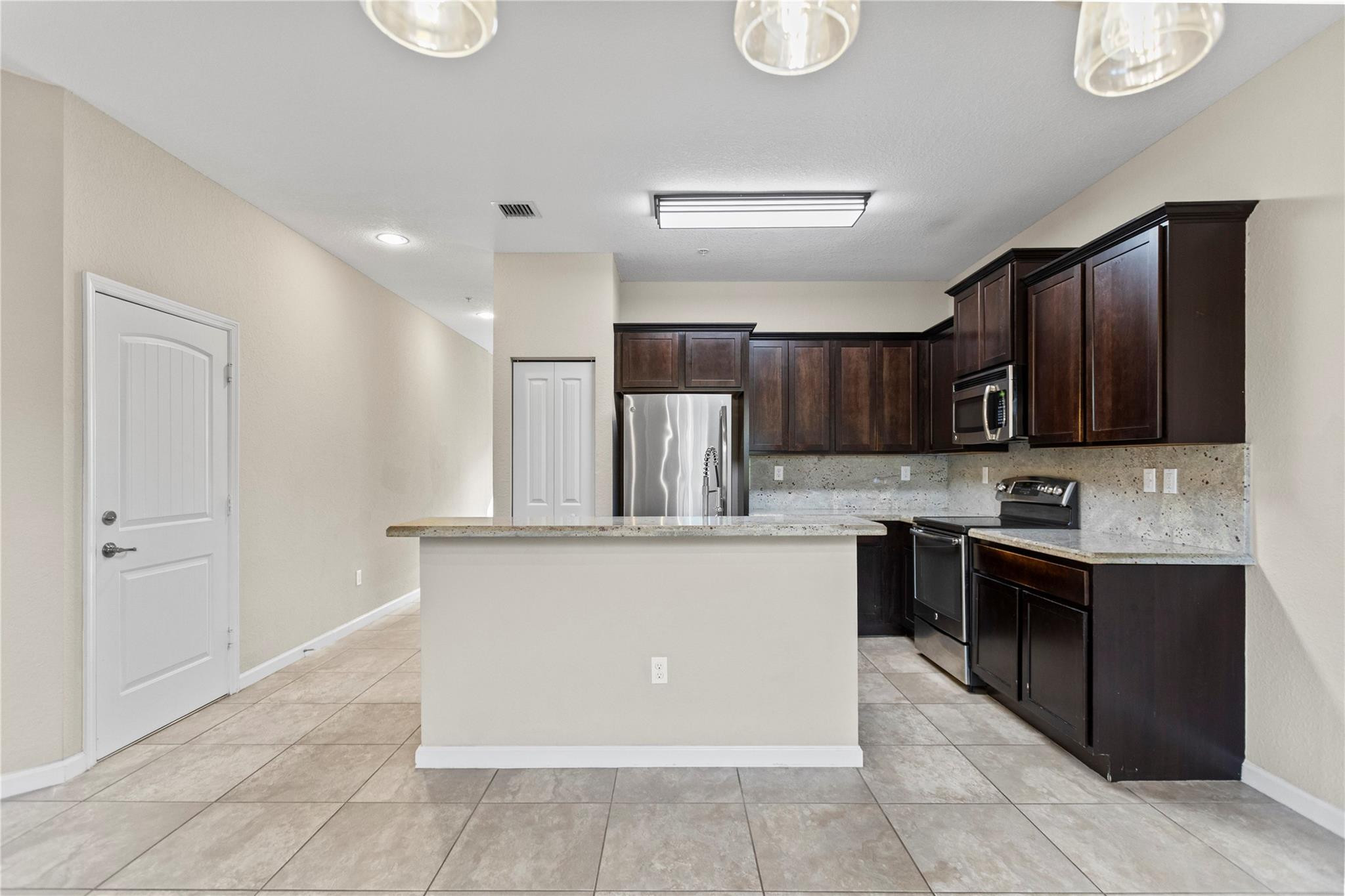 259 Southwest 7th Street, Unit 259 Pompano Beach, FL 33060 - Photo 21 of 87 a kitchen with stainless steel appliances granite countertop a stove top oven a sink dishwasher and a refrigerator