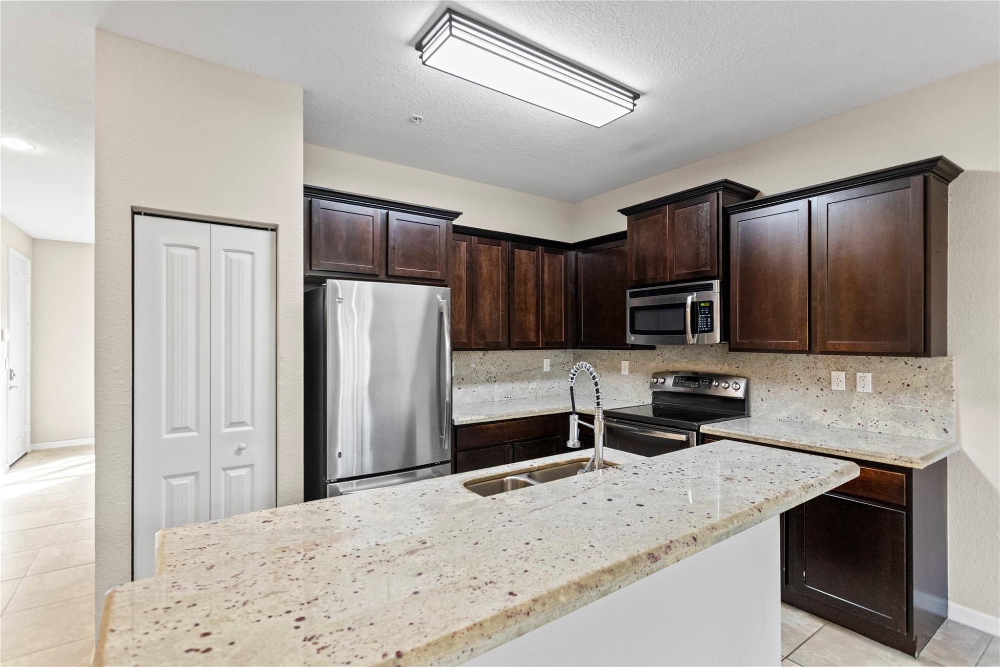 259 Southwest 7th Street, Unit 259 Pompano Beach, FL 33060 - Photo 25 of 87 a kitchen with stainless steel appliances a refrigerator and a stove top oven