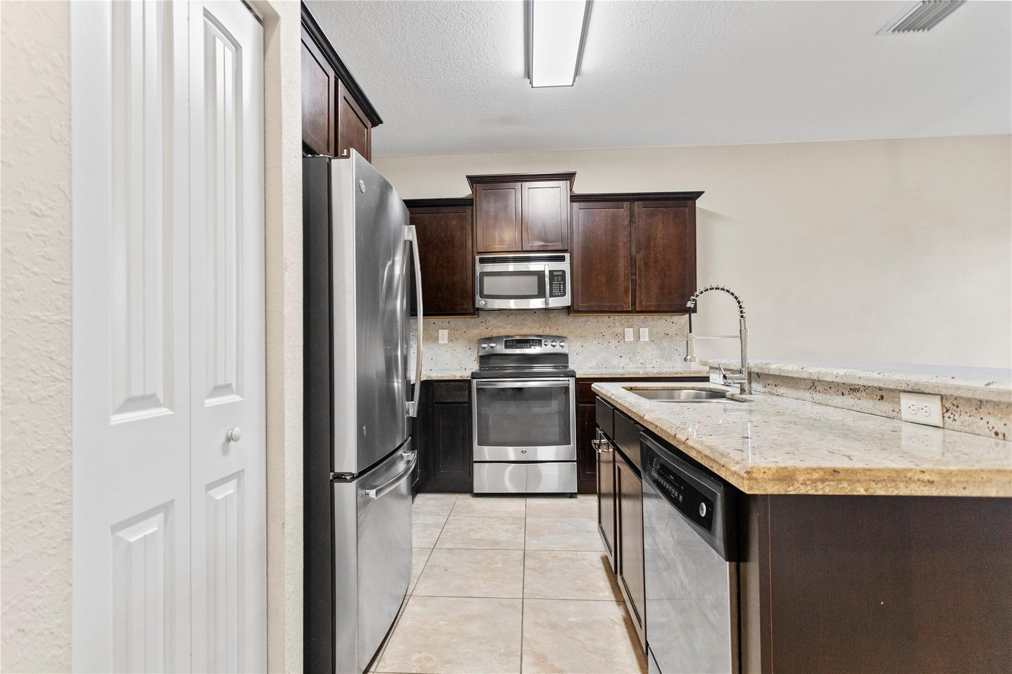 259 Southwest 7th Street, Unit 259 Pompano Beach, FL 33060 - Photo 26 of 87 a kitchen with stainless steel appliances granite countertop a stove sink and refrigerator
