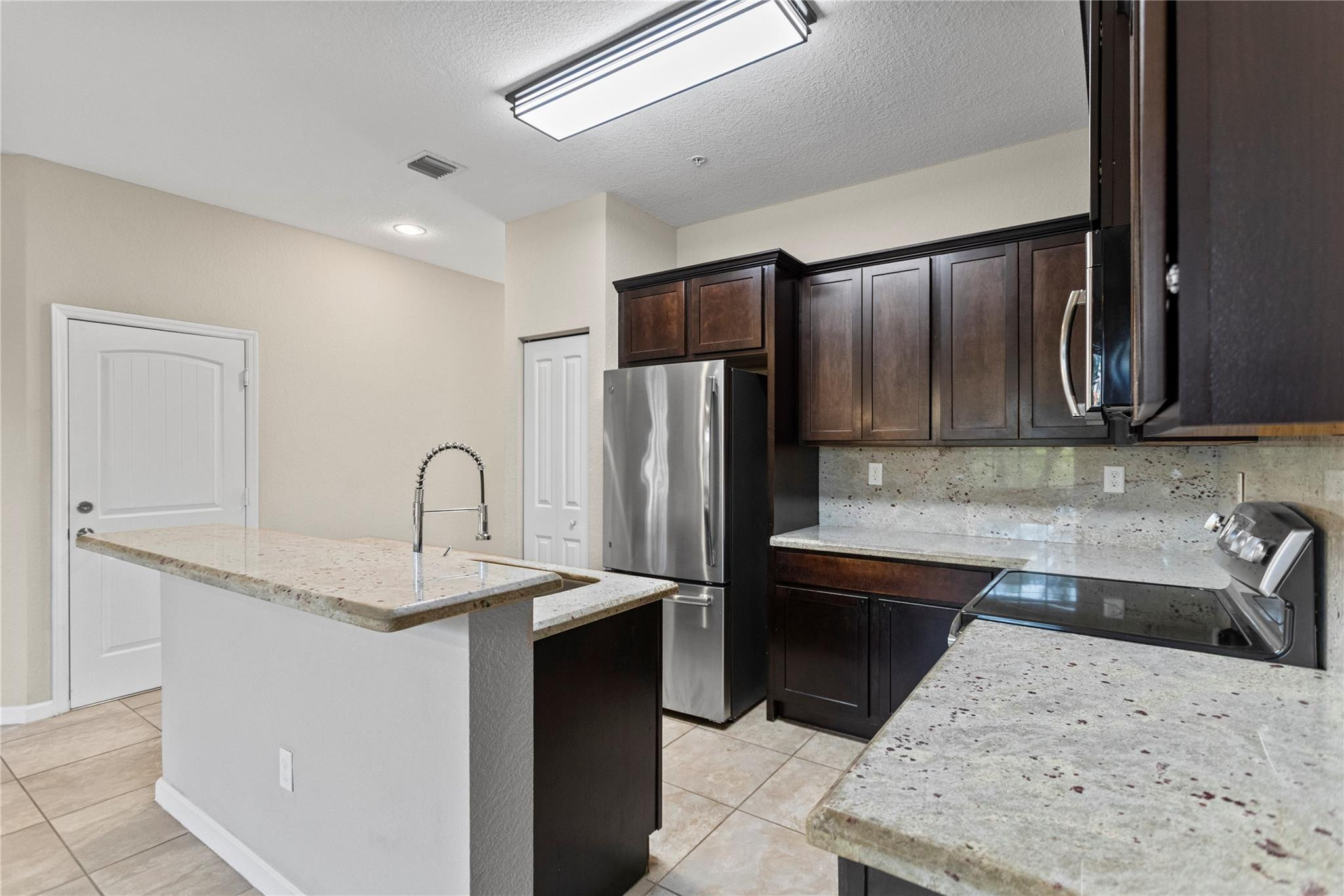 259 Southwest 7th Street, Unit 259 Pompano Beach, FL 33060 - Photo 27 of 87 a kitchen with stainless steel appliances granite countertop a sink refrigerator and cabinets