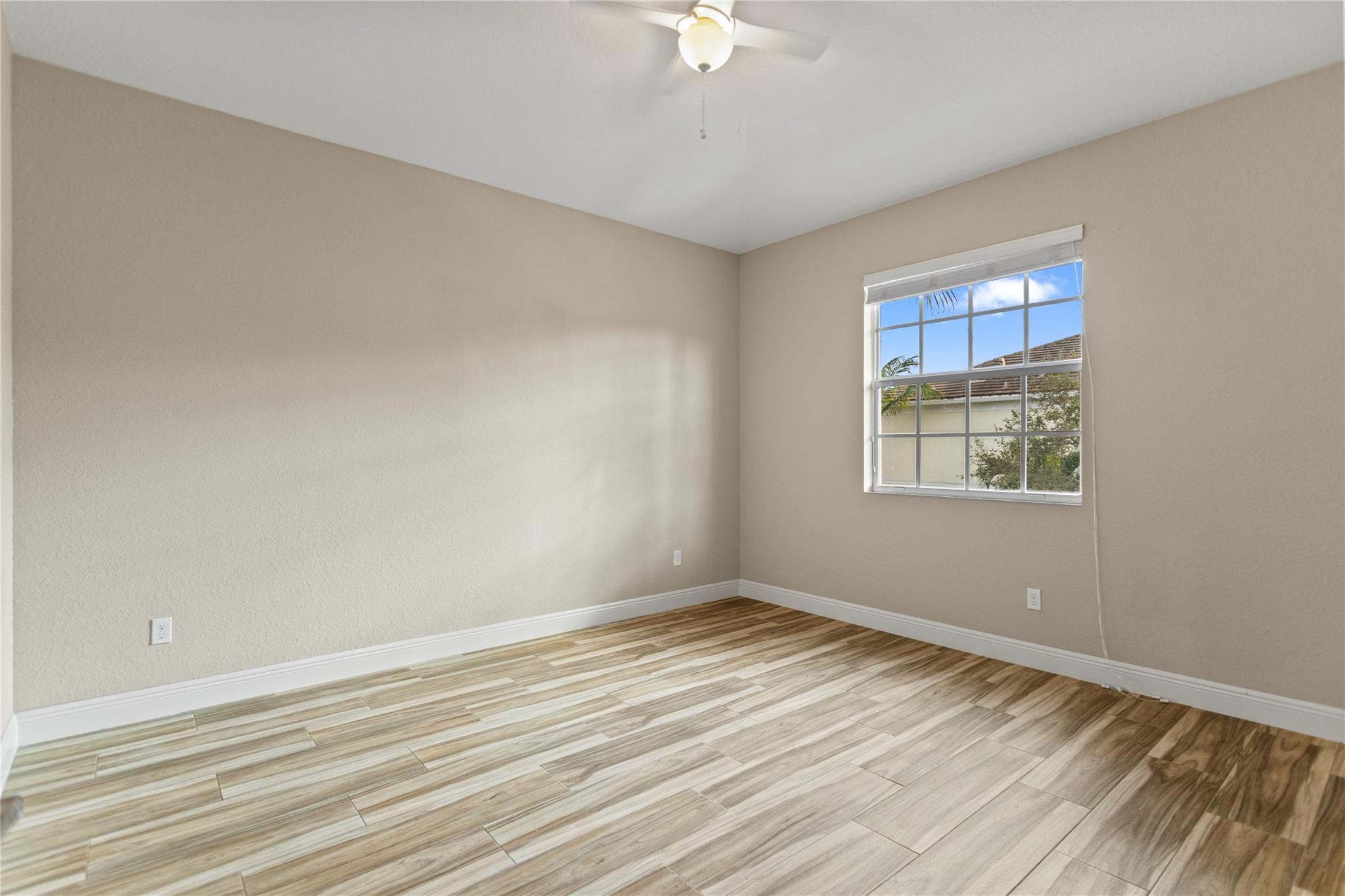 259 Southwest 7th Street, Unit 259 Pompano Beach, FL 33060 - Photo 38 of 87 a view of an empty room with wooden floor and a window