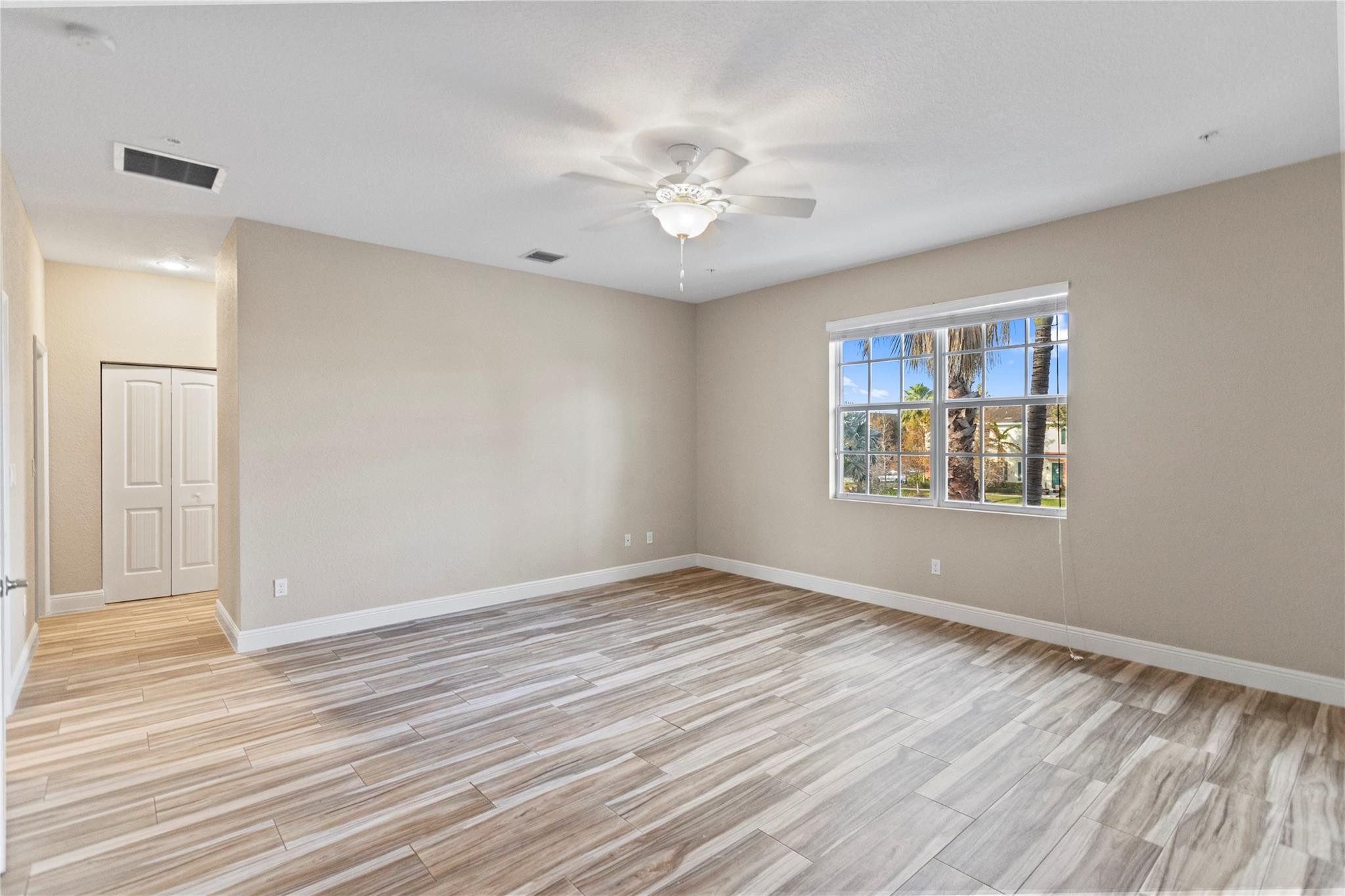 259 Southwest 7th Street, Unit 259 Pompano Beach, FL 33060 - Photo 48 of 87 a view of an empty room with wooden floor and a window