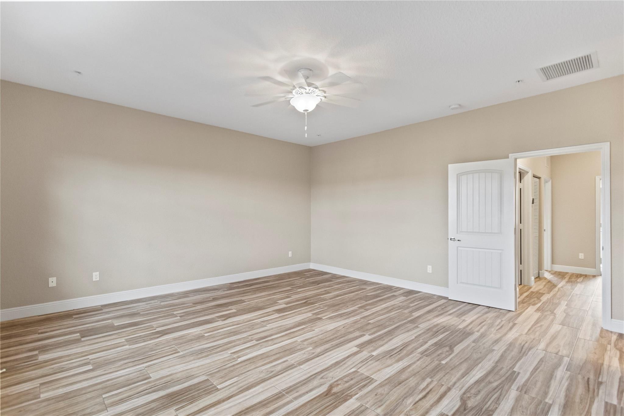 259 Southwest 7th Street, Unit 259 Pompano Beach, FL 33060 - Photo 55 of 87 a view of a room with wooden floor and a ceiling fan
