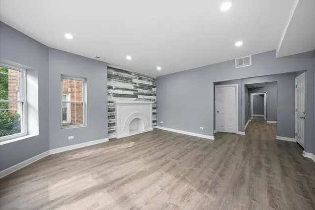 a view of empty room with wooden floor and window
