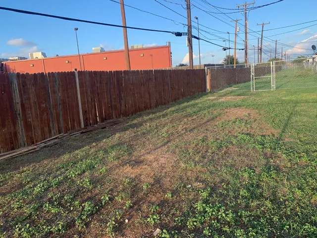 a view of a backyard with wooden fence
