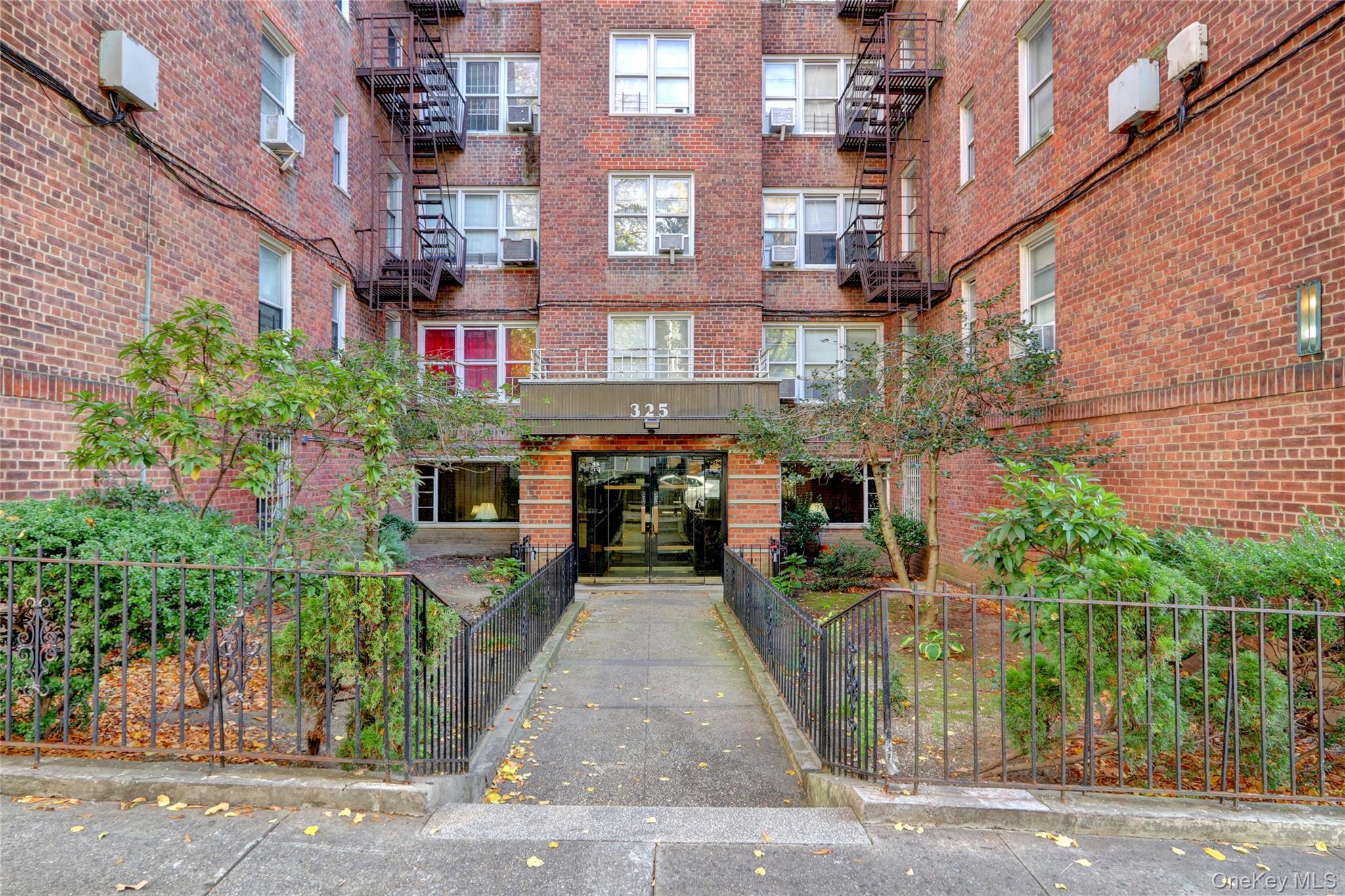 325 East 201st Street, Unit 3J Bronx, NY 10458 - Photo 1 of 33 a front view of a building with garden