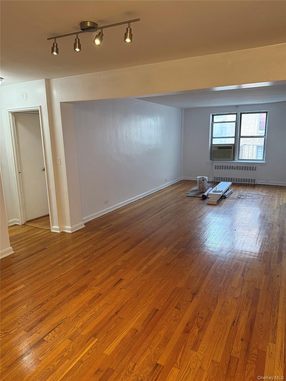 325 East 201st Street, Unit 3J Bronx, NY 10458 - Photo 14 of 33 an empty room with wooden floor and windows