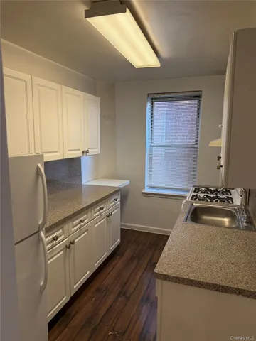 a kitchen with granite countertop wooden floors and sink