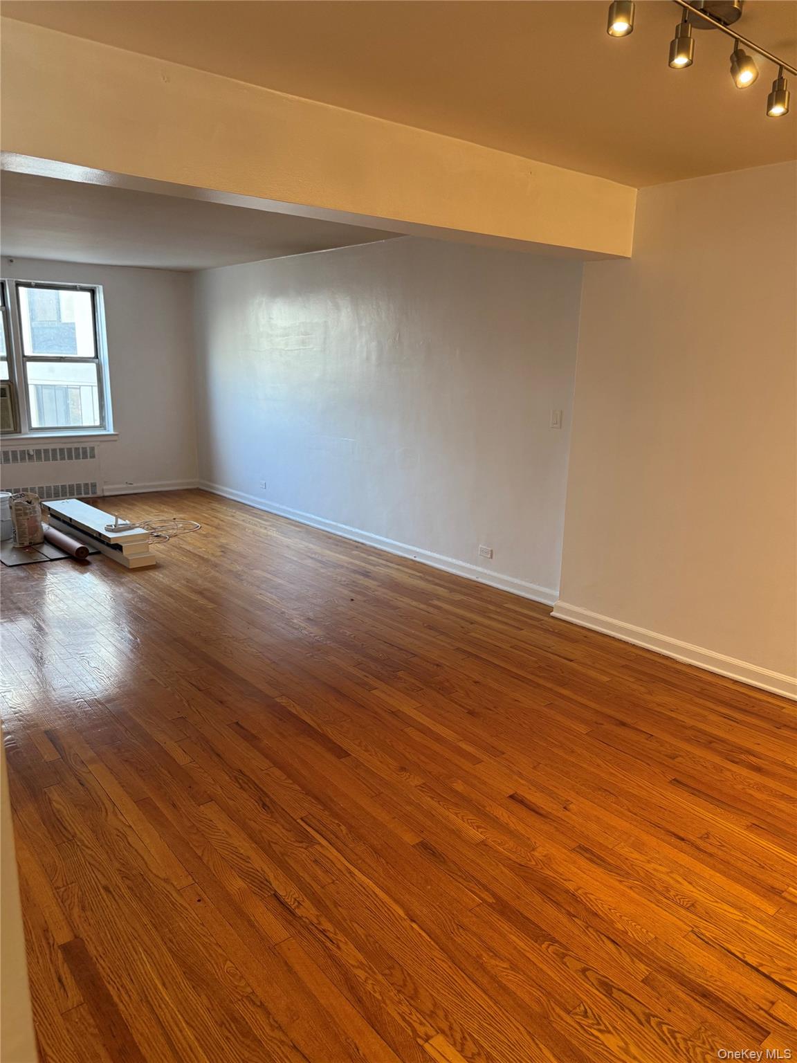 325 East 201st Street, Unit 3J Bronx, NY 10458 - Photo 26 of 33 an empty room with wooden floor and windows
