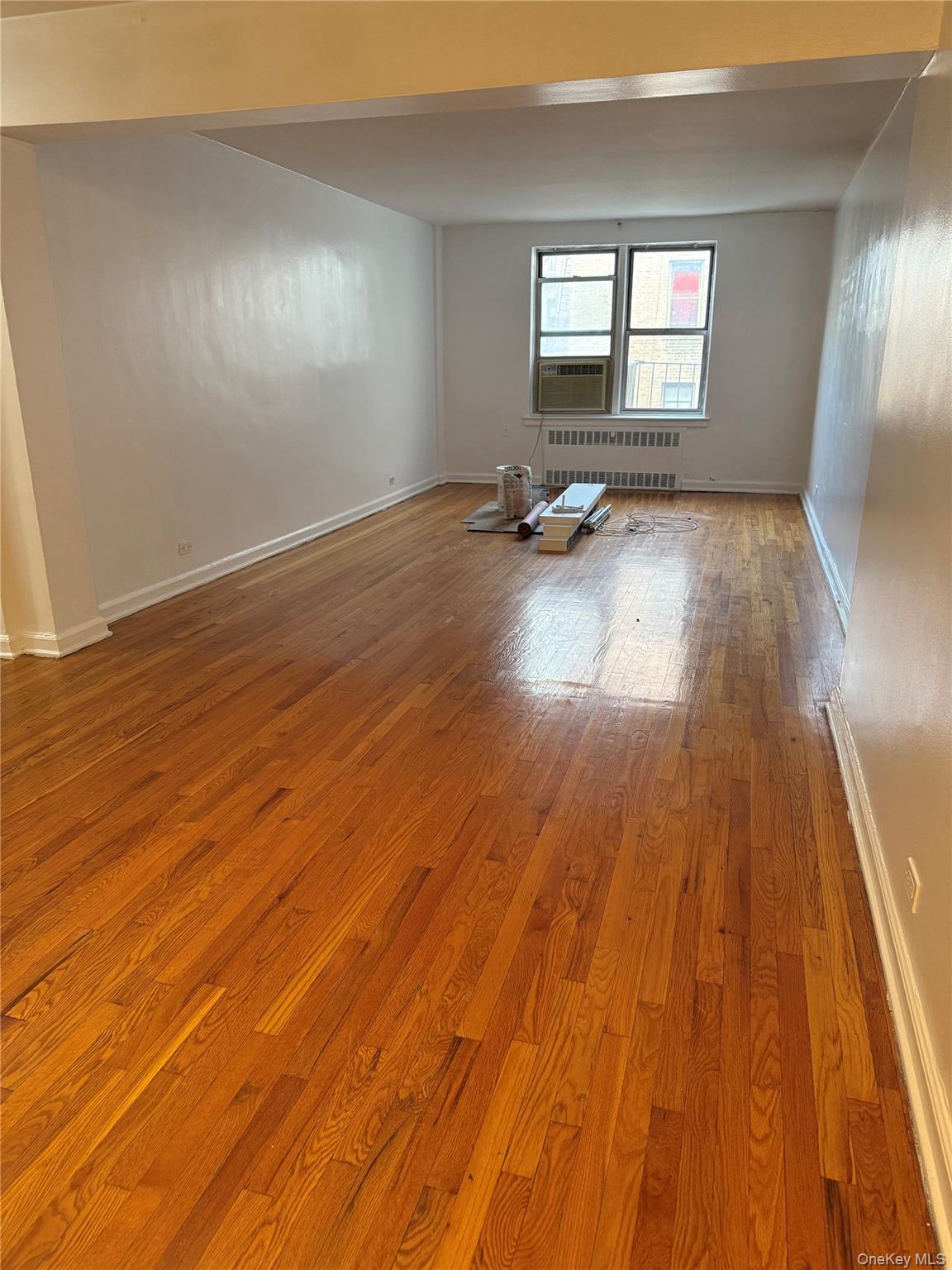325 East 201st Street, Unit 3J Bronx, NY 10458 - Photo 10 of 33 an empty room with wooden floor and windows