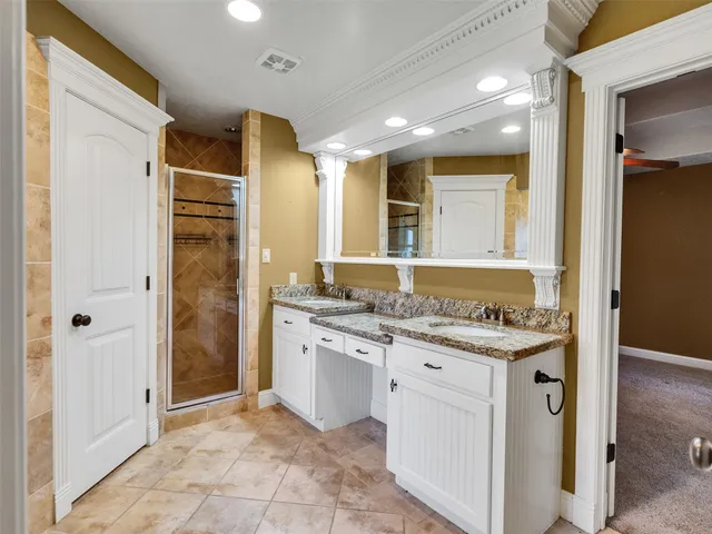 a bathroom with a granite countertop sink a mirror and a shower
