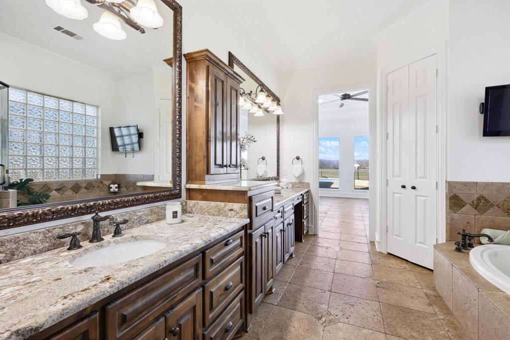 12886 St John Road Pilot Point, TX 76258 - Photo 17 of 35 Full bath featuring stone tile flooring, a bath, crown molding, a ceiling fan, and vanity