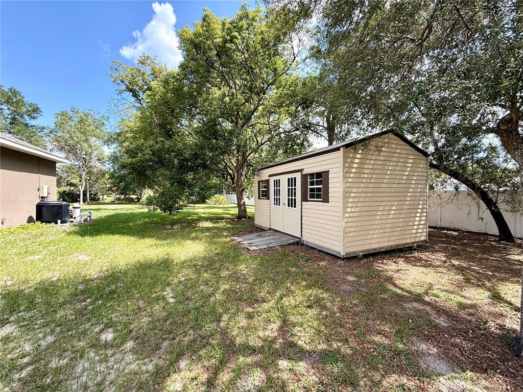 13110 Bamboo Street Spring Hill, FL 34609 - Photo 54 of 56 a view of a house with backyard and trees