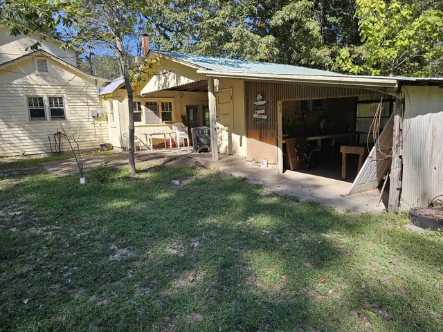 a view of a backyard with table and chairs under an umbrella
