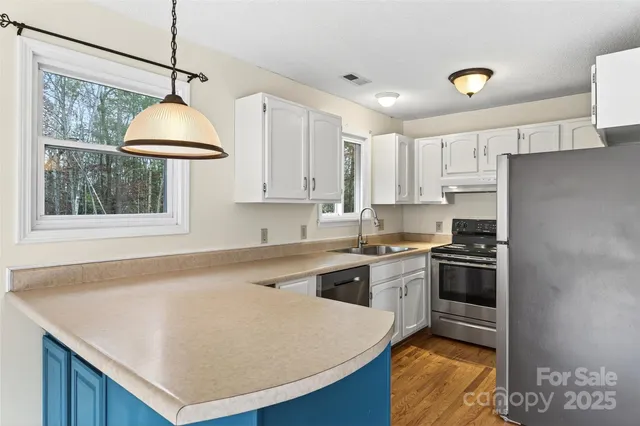 a kitchen with stainless steel appliances granite countertop a sink a stove and a refrigerator