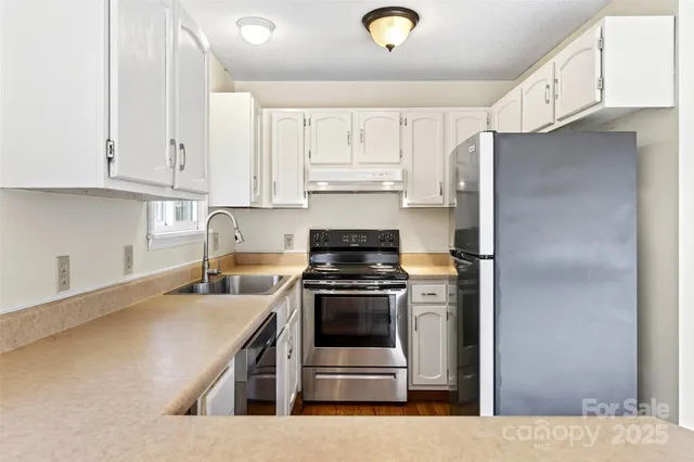 a kitchen with stainless steel appliances granite countertop a stove a refrigerator and a sink