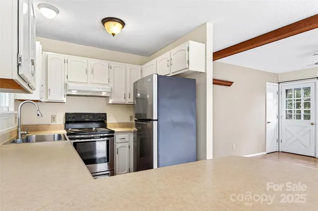 a kitchen with stainless steel appliances granite countertop a refrigerator stove and a sink