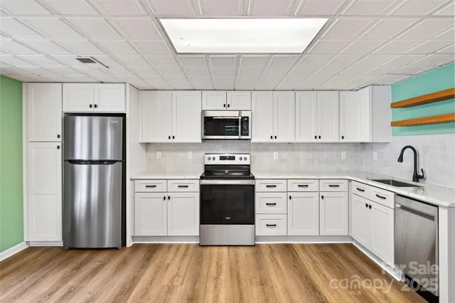 a kitchen with stainless steel appliances a stove a sink and a refrigerator