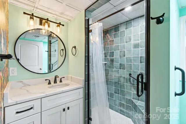 a bathroom with a granite countertop sink a mirror a vanity and shower