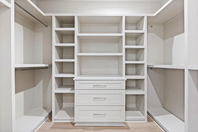 a view of walk in closet with empty racks