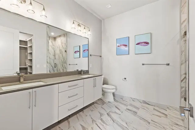 a bathroom with a granite countertop sink mirror vanity and toilet