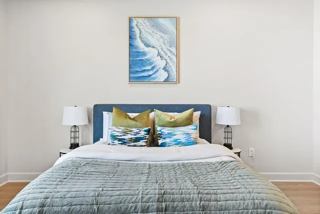 a bedroom with a bed and a painting on the wall