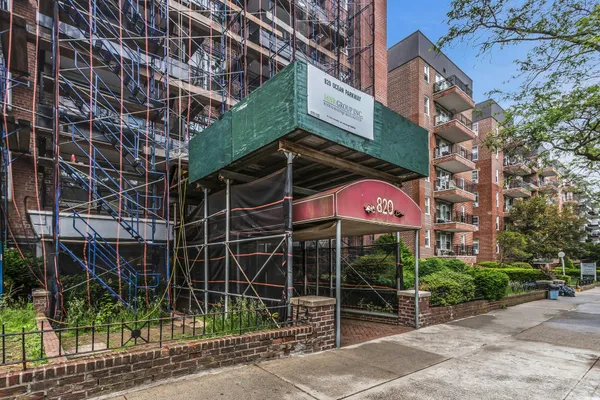 a front view of a building with glass windows and a fence