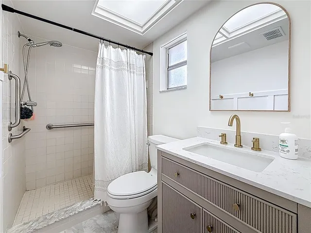 a bathroom with a sink a toilet and shower