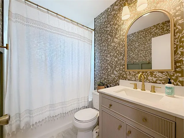 a bathroom with a sink a toilet and shower curtain