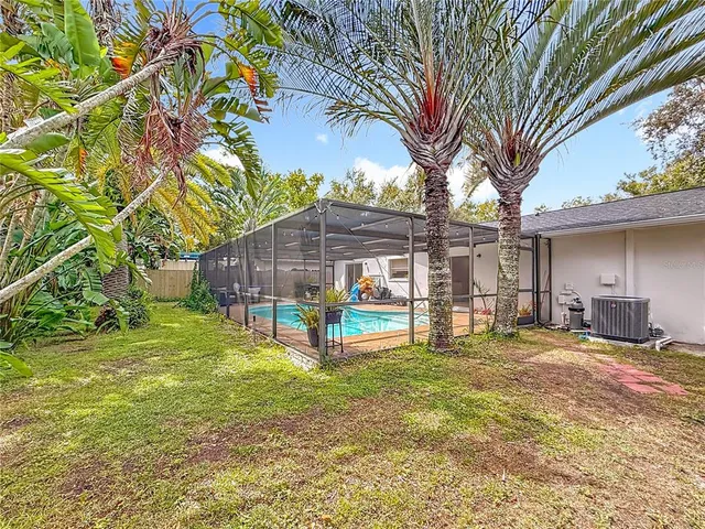 a view of a house with backyard and a tree