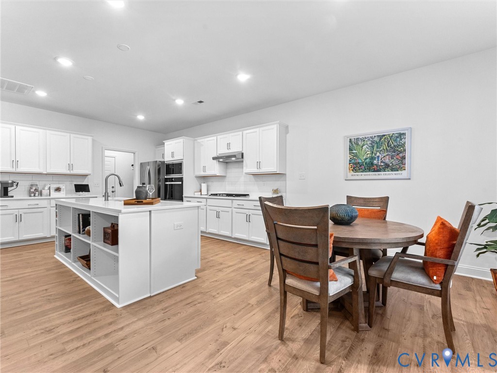 13736 Randolph Pond Lane Midlothian, VA 23114 - Photo 8 of 37 a kitchen with stainless steel appliances kitchen island granite countertop a table chairs and a refrigerator