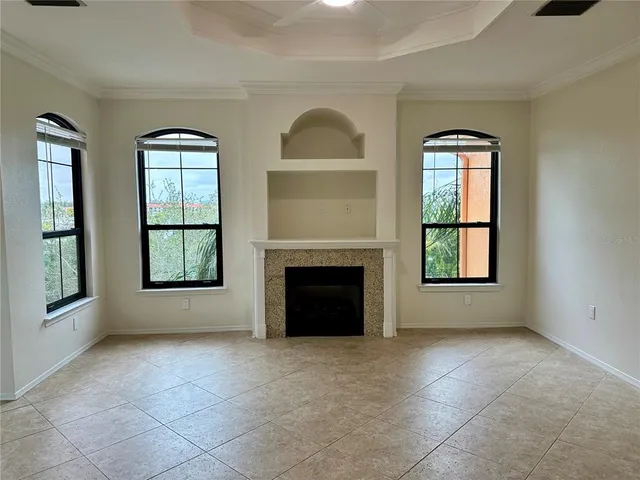an empty room with windows and fireplace