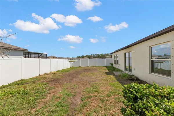 a view of backyard of house and car parked