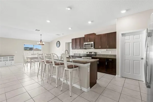 a large kitchen with stainless steel appliances granite countertop a sink a stove and cabinets