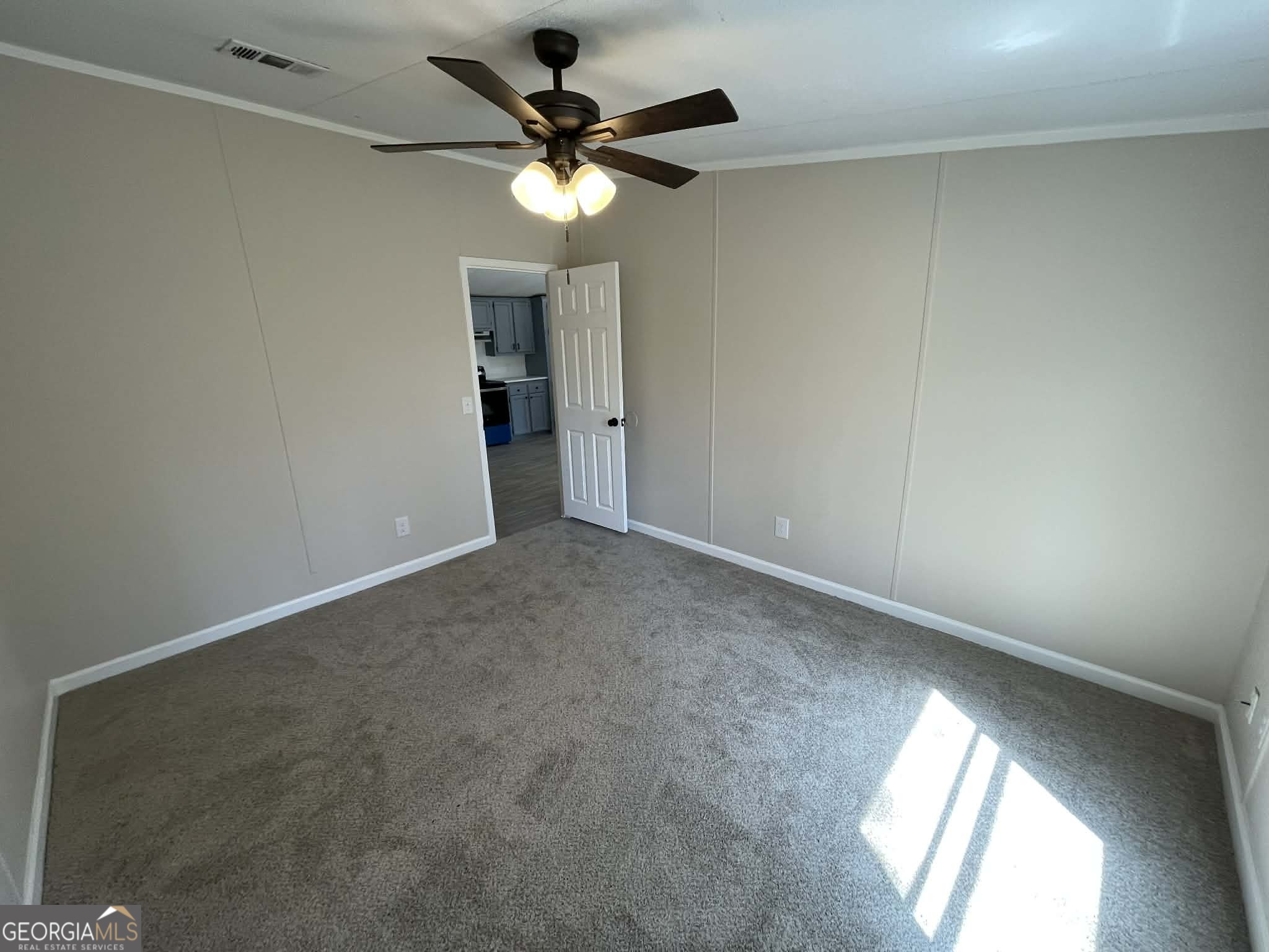 105 Senimor Court Perry, GA 31069 - Photo 19 of 27 an empty room with a chandelier fan and windows