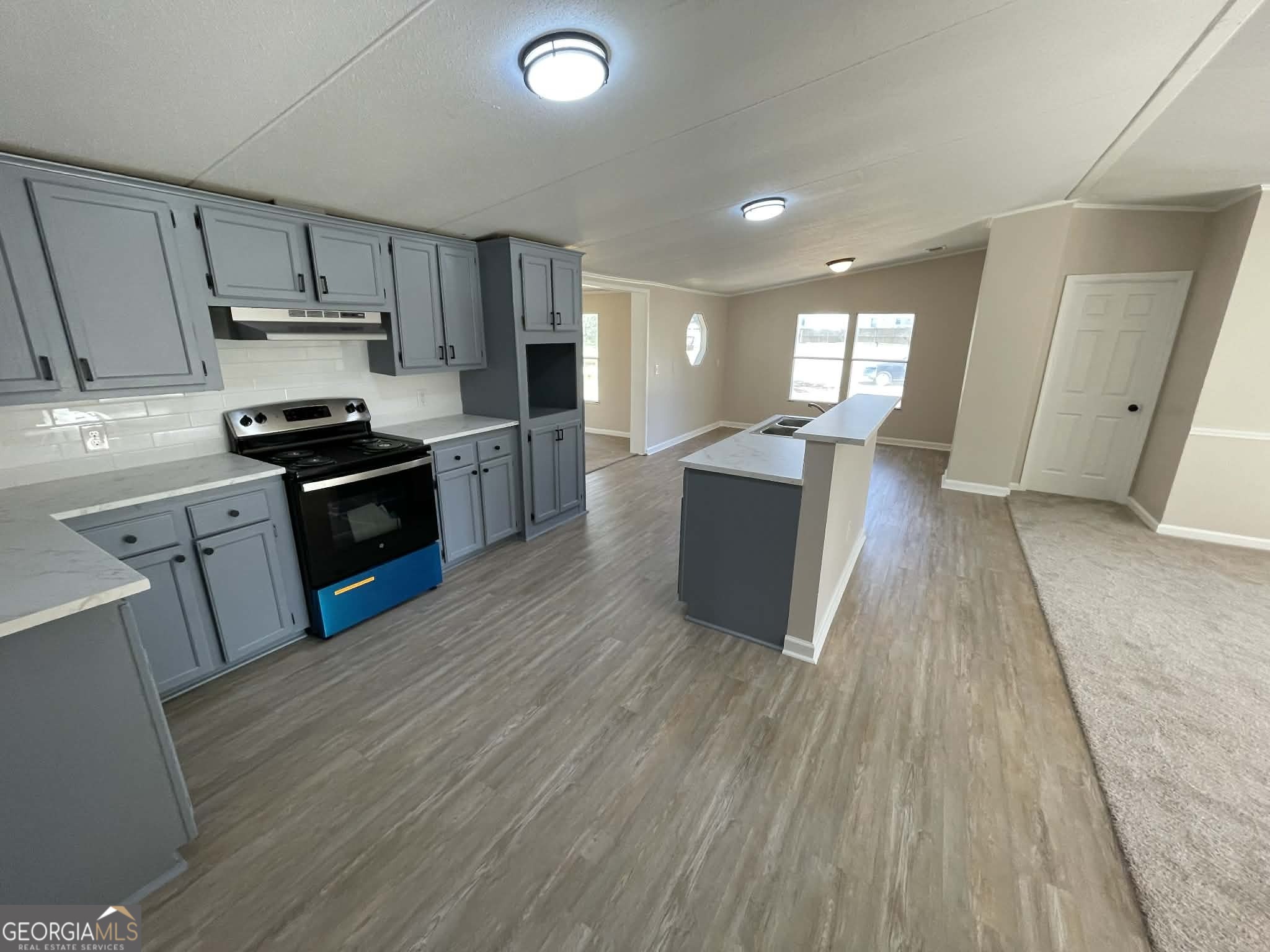 105 Senimor Court Perry, GA 31069 - Photo 9 of 27 a kitchen with wooden floors and stainless steel appliances